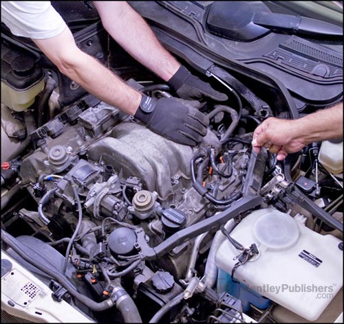 Bentley technical 
editors removing intake manifold on V6 (M 112) engine.(BentleyPublishers.com watermark not printed on actual product.)